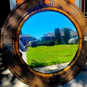 Large round mirror with a brown finish surrounding the mirror